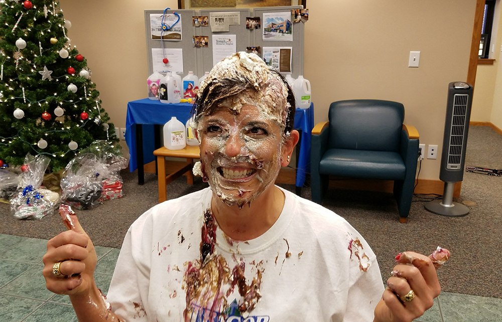TRICOR employee with pie on her face and shirt as part of 