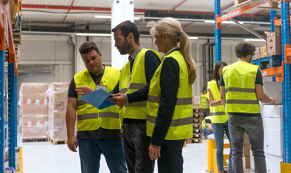 TRICOR agent working with two employees in a warehouse