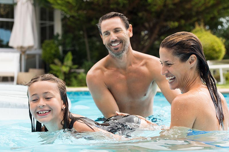 Husband and wife teaching their daughter how to swim